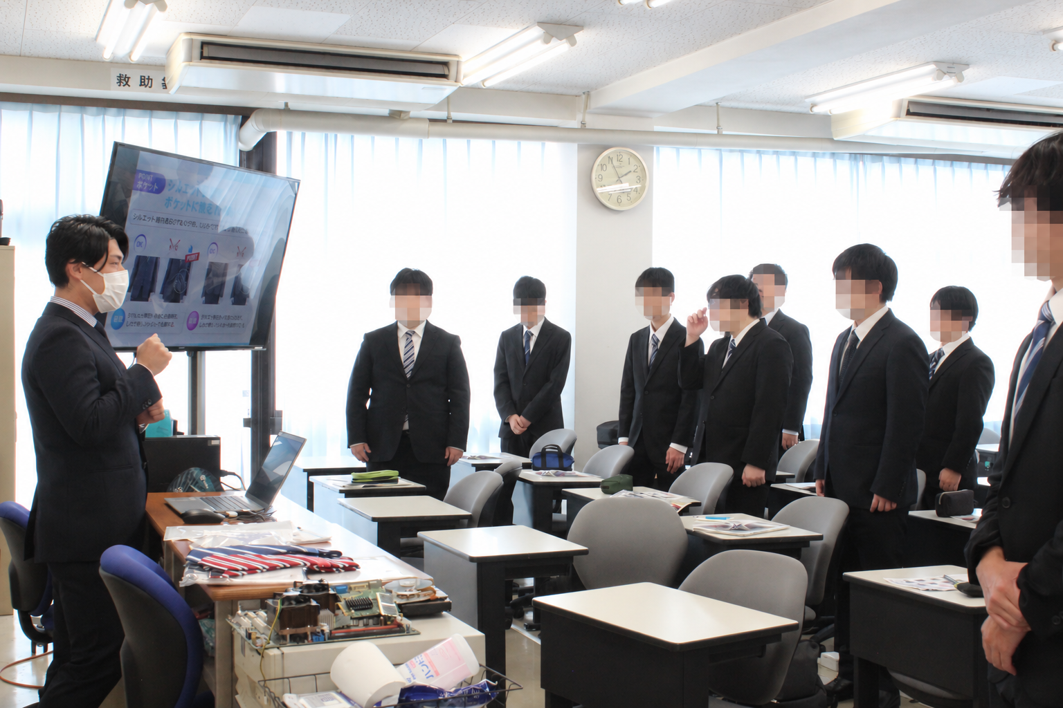 男子学生がスーツ着こなし講座の実演に参加する様子