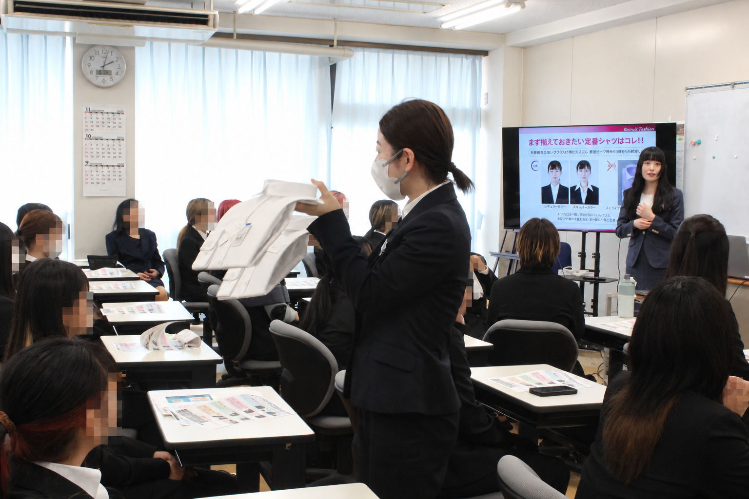 女子会場で衣服を用いて説明する講師
